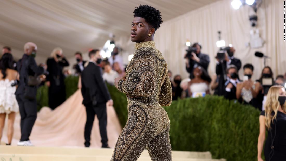 Finally, a group of suited men pulled the armor apart to reveal Lil Nas X&#39;s final look: a golden, glittering catsuit.