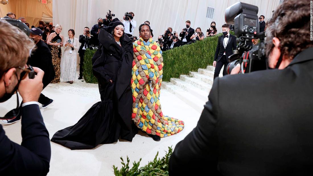 Singer Rihanna and A Rocky swooped in at the very last minute, closing out the Met Gala red carpet in a pair of bold looks. Rihanna wore a voluminous Balenciaga couture coat dress, accessorized with a beanie and diamond forehead accessory. A Rocky meanwhile wore a colorful quilted creation by ERL.