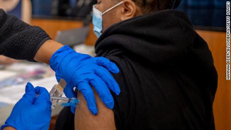 A healthcare worker administers a dose of the Pfizer-BioNTech Covid-19 vaccine to a teenager at West Philadelphia High School in Philadelphia on August 4, 2021. 