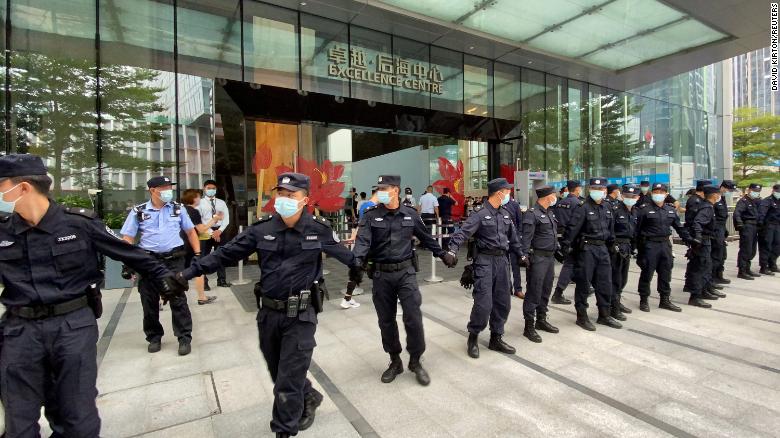 Security personnel form a human chain as they guard outside the Evergrande's headquarters, where people gathered to demand repayment of loans and financial products, in Shenzhen, Guangdong province, China September 13, 2021
