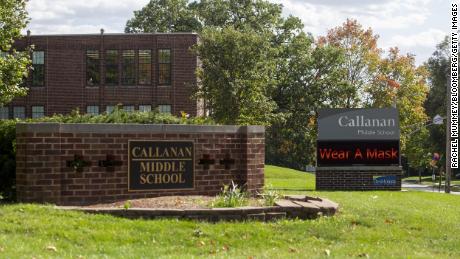 A sign reminds people to wear a mask outside Callanan Middle School in Des Moines, Iowa, in September 2020. Des Moines Public Schools officials announced Monday that the district&#39;s mask mandate will be reinstated following a ruling that places the state&#39;s mandate ban on hold. 