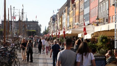 People walk along Nyhavn, a colorful harbor popular with visitors, in Denmark&#39;s capital, Copenhagen, on September 3.