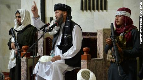 Armed Taliban fighters stand next to a Mullah, a religious leader, speaking during Friday prayers at the Pul-e Khishti Mosque in Kabul on September 3.