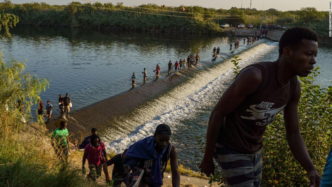 Migrants cross the Rio Grande to get food and supplies near the Del Rio port of entry in Ciudad Acuña, Mexico, on Saturday, September 18.