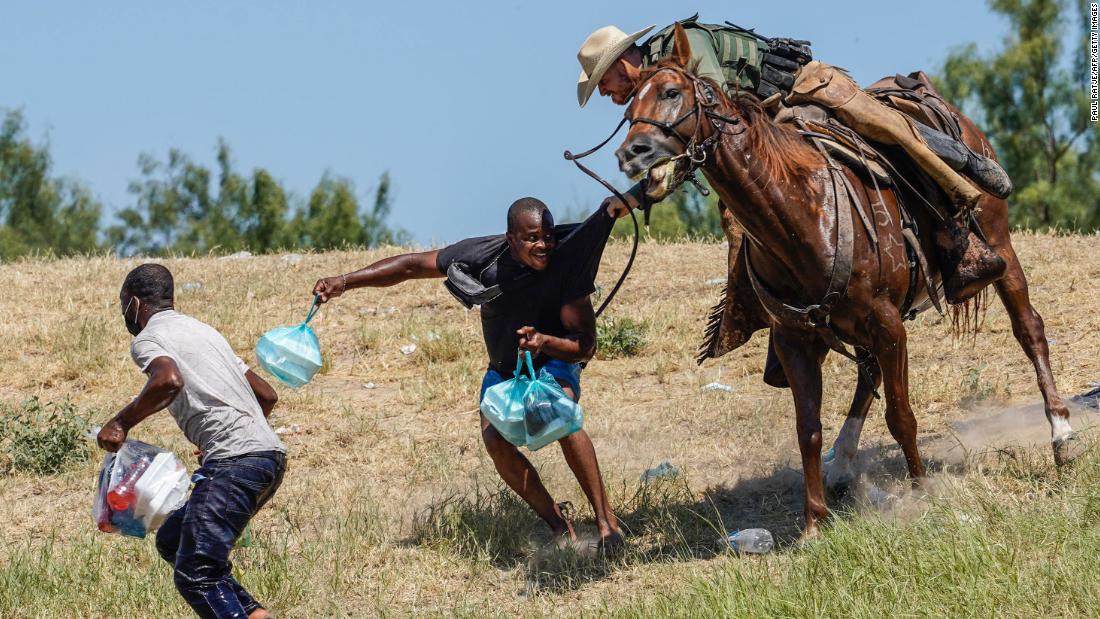 United States Border Patrol agents on horseback try to stop migrants from entering an encampment on the banks of the Rio Grande near the Del Rio International Bridge in Del Rio, Texas, on September 19.