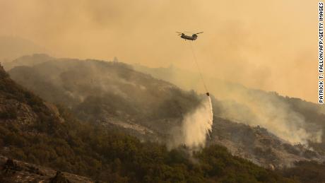 A Chinook firefighting helicopter carries water to drop it on the blaze as the KNP complex blaze in Sequoia National Park continues to rage.