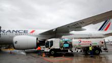 Workers refuel an Airbus A350 with sustainable aviation fuel at Roissy airport, north of Paris, on May 18, 2021. Air France-KLM is sending into the air what it calls its first long-haul flight with sustainable aviation fuel Tuesday. The plane is said to be using petroleum mixed with a synthetic jet fuel derived from waste cooking oils. 