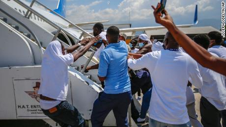 Haitians deported from the US try to board the same plane in which they were deported, at Port-au-Prince airport on Tuesday.