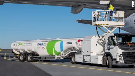A tanker truck fuels a plane with SAF produced by Finland&#39;s Neste at Helsinki Airport.