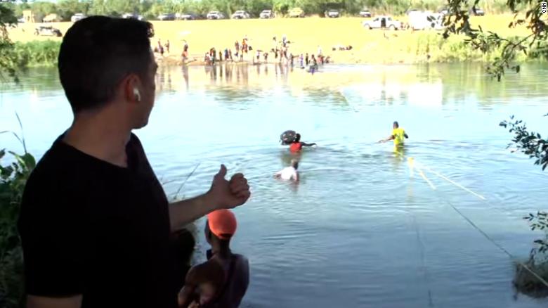 Migrants cross Rio Grande River during CNN reporter's liveshot