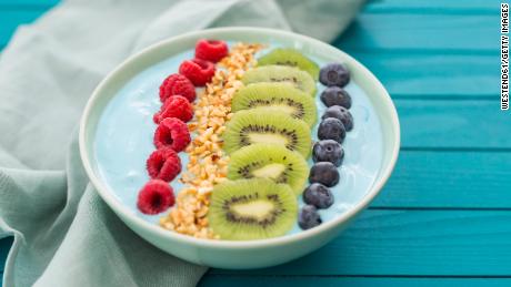 This colorful smoothie bowl features fresh berries, kiwi and chopped hazelnuts.