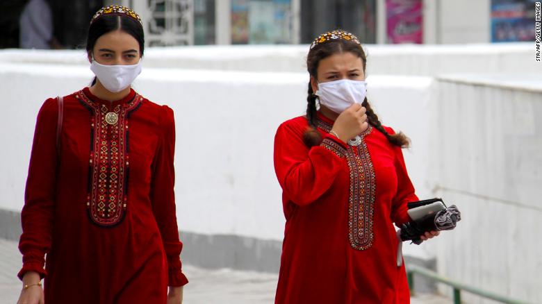 Turkmen women wearing face masks walk in Ashgabat on July 13, 2020. 