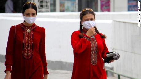 Turkmen women wearing face masks walk in Ashgabat on July 13, 2020. 