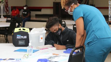 At a teen-focused Covid-19 vaccine clinic, 15-year-old Raymond Slaughter fills out his paperwork before getting his first shot.