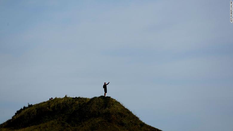 A fan watches from a hill on the 11th hole during a Foursome match the Ryder Cup at the Whistling Straits.