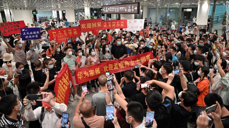 Crowds hold banners and placards reading &quot;welcome home Meng Wanzhou&quot; as they wait for Huawei executive Meng Wanzhou at Shenzhen Bao&#39;an International Airport on September 25.