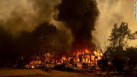 Flames consume a house as the Fawn Fire burns north of Redding on September 23.