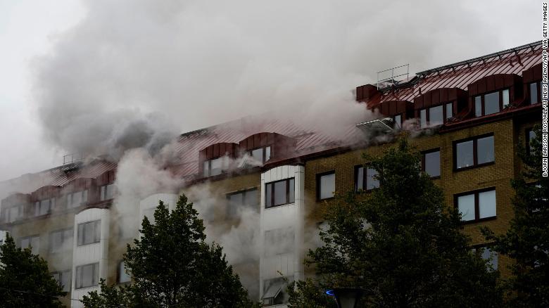 Smoke billows from a building as emergency services fight a fire caused by an explosion in central Gothenburg.