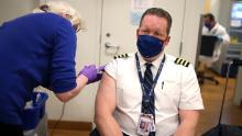 CHICAGO, ILLINOIS - MARCH 09: United Airlines pilot Steve Lindland receives a COVID-19 vaccine from RN Sandra Manella at United&#39;s onsite clinic at O&#39;Hare International Airport on March 09, 2021 in Chicago, Illinois. United has been vaccinating about 250 of their O&#39;Hare employees at the clinic each day for the past several days.   (Photo by Scott Olson/Getty Images)