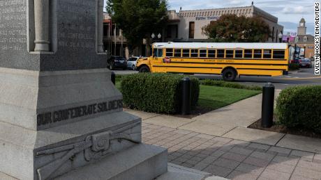 A Williamson County School bus drives past the Confederate monument which stands in the center of the town square in Franklin, Tennessee.