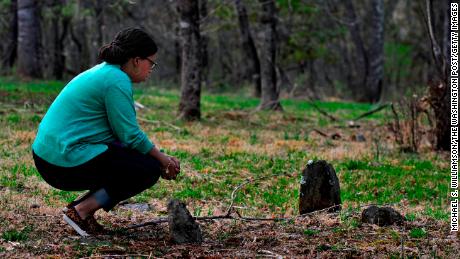 Bethany Pace  kneels at the simple stone monuments that mark the graves of slaves that were her kin, in Sweet Briar, Virginia, in 2015.
