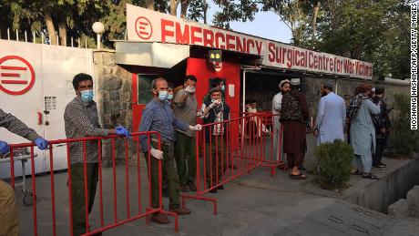 Afghan medical staff members stand at the entrance of a hospital as they wait to receive the victims of an explosion in Kabul on October 3, 2021. (Photo by Hoshang HASHIMI / AFP) (Photo by HOSHANG HASHIMI/AFP via Getty Images)