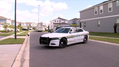 A patrol car is parked near the home where the sheriff&#39;s office says Shaun Paul Runyon attacked and killed three of his coworkers in Davenport, Florida.