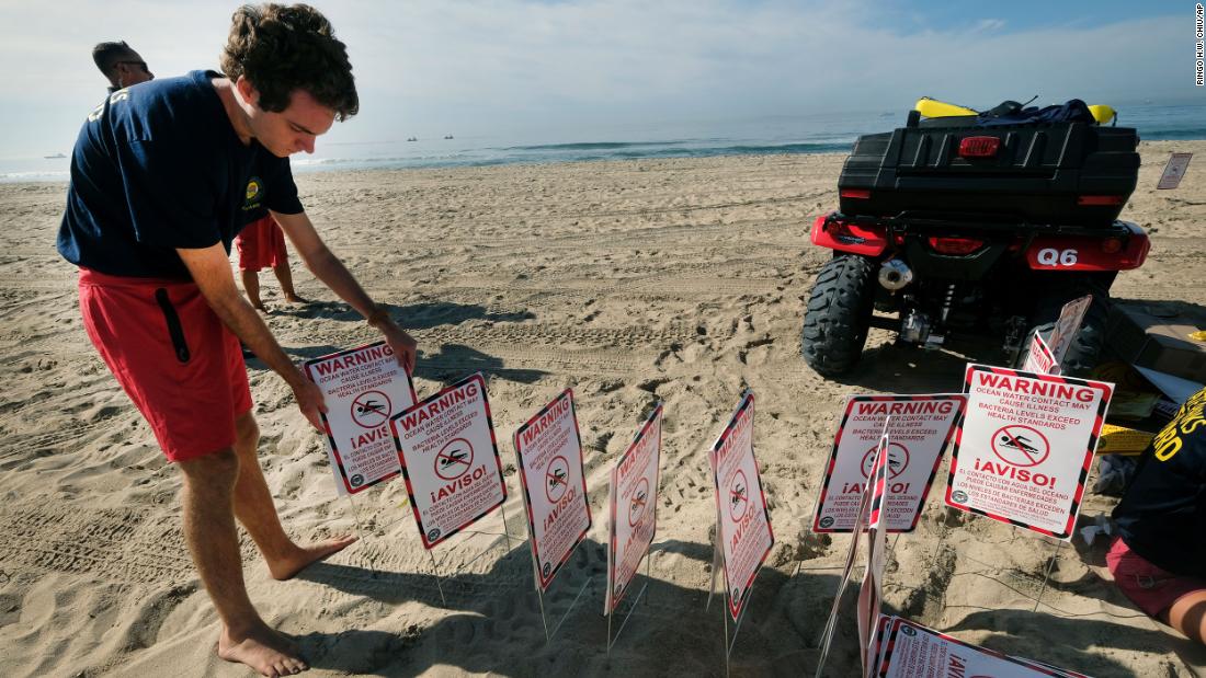 Lifeguards post warning signs in Huntington Beach.