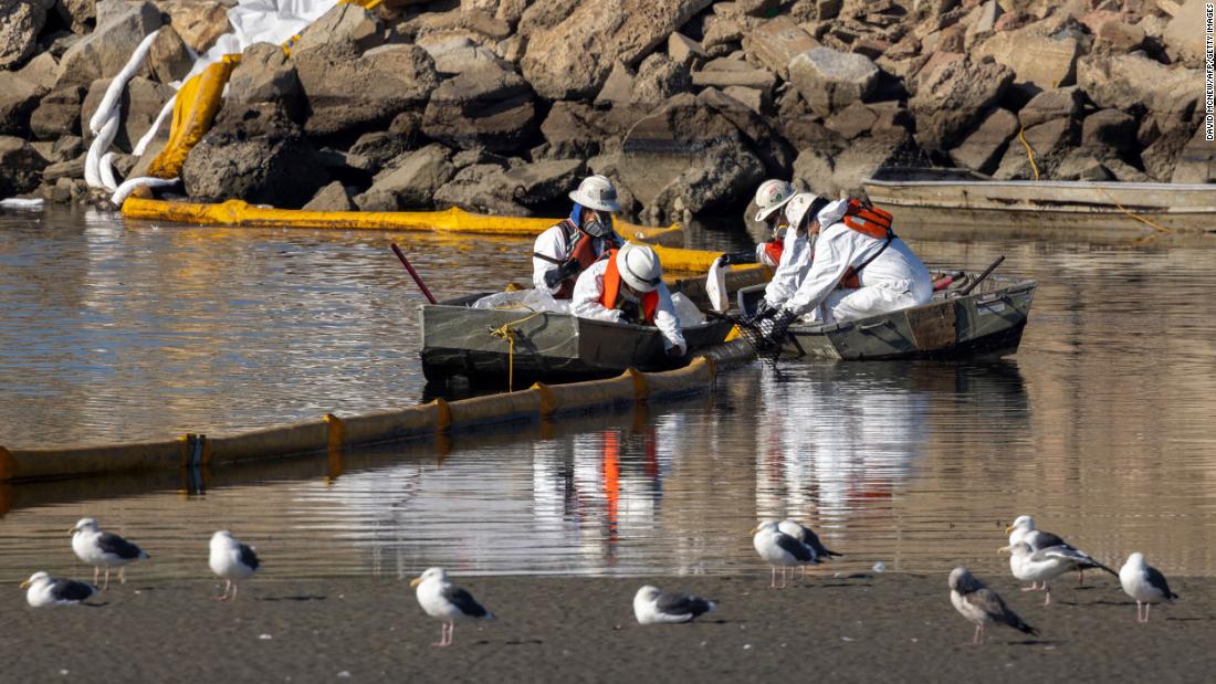 Workers try to clean up floating oil in the Talbert Marsh area.