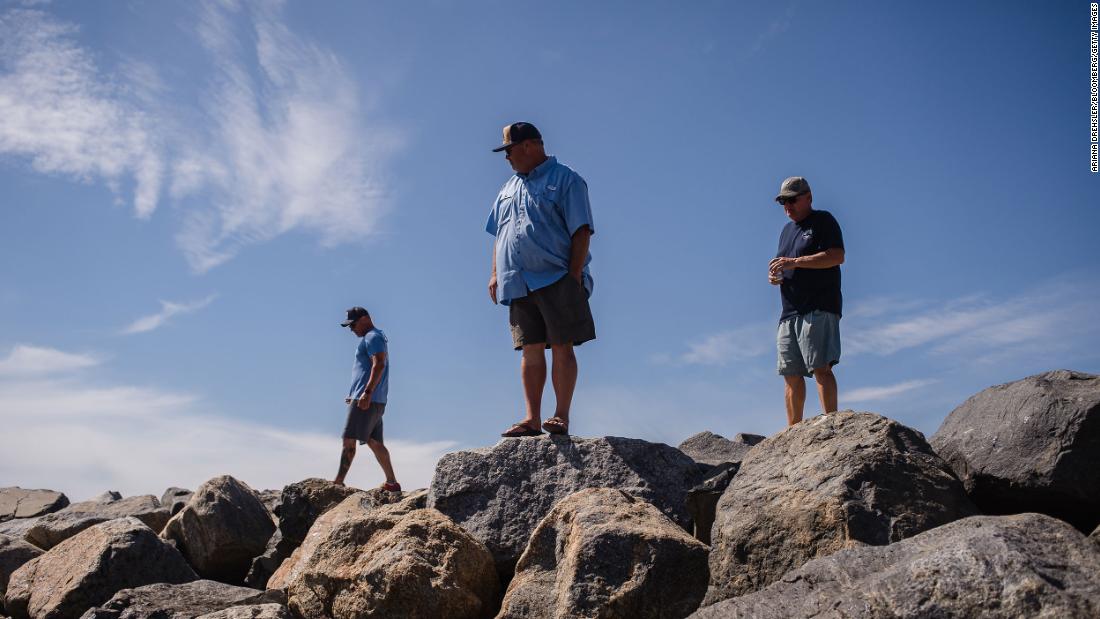 Local residents look for signs of damage in Huntington Beach.