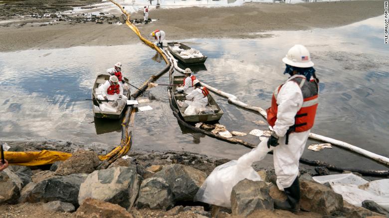 Workers with Patriot Environmental Services clean up some of the oil that flowed into the Talbert Marsh in Huntington Beach, California.