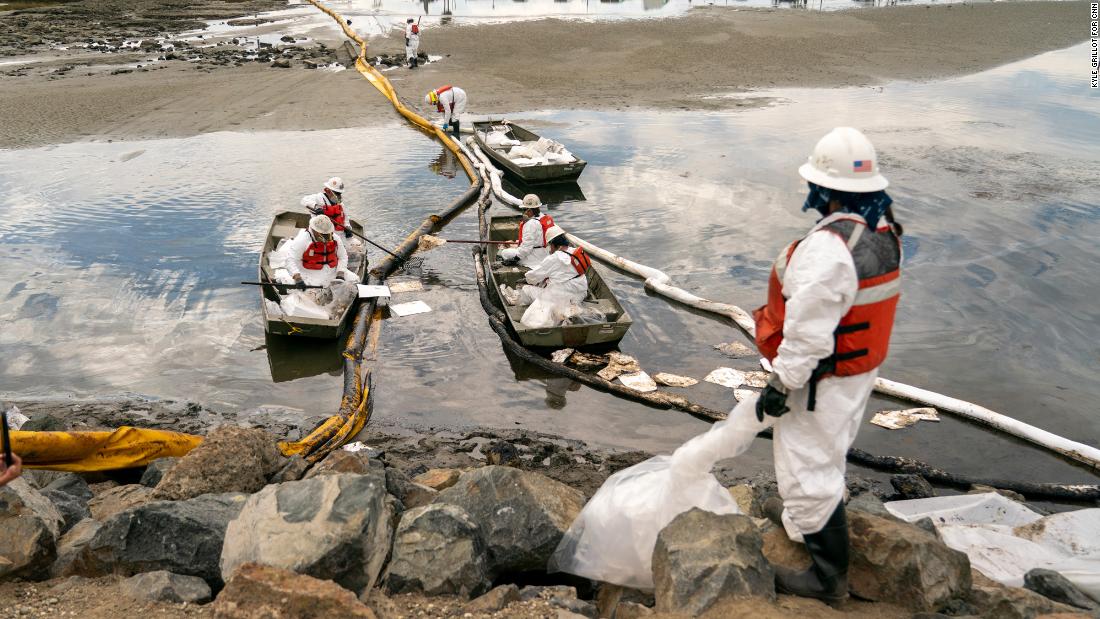 Workers with Patriot Environmental Services clean up some of the oil that flowed into the Talbert Marsh.