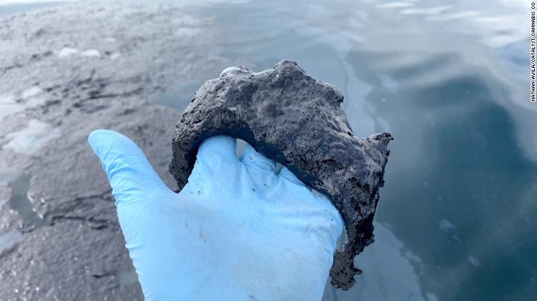 Elliot Lewis holds a glob of oil as he and Nathan Avila traveled into the Pacific to film the oil spill. 