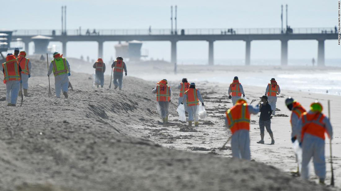 Workers clean up debris in Huntington Beach on October 5.