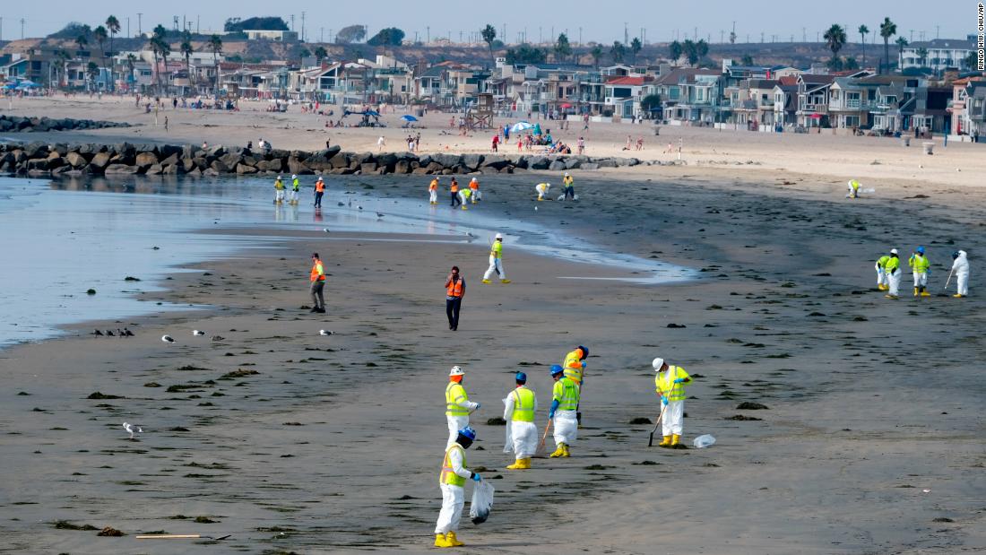 Workers clean a contaminated area of Newport Beach on October 6.