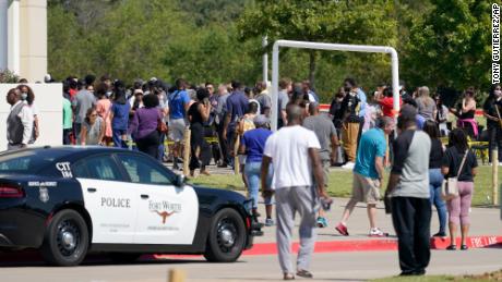 Families stand outside the Mansfield ISD Center for the Performing Arts waiting to be reunited with their children on Wednesday in Mansfield, Texas, after a shooting at Timberview High School in Arlington. 