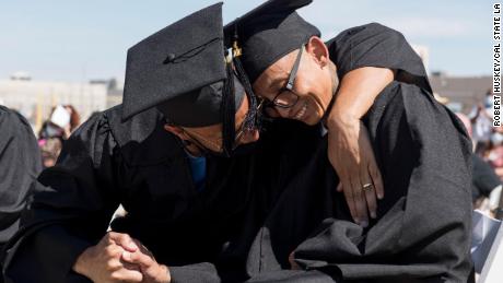 Two incarcerated students embrace during their graduation ceremony.
