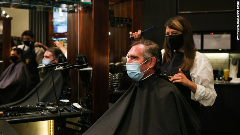 NSW Premier Dominic Perrottet receives a haircut on October 11, following the easing of Covid-19 restrictions in the state.