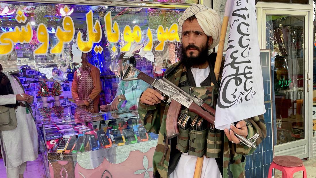 A Taliban fighter waits outside an electronics shop in Ghazni.