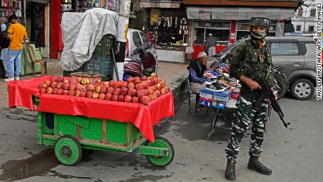 A member of the Indian security forces stands guard at a market in Srinagar on October 11.