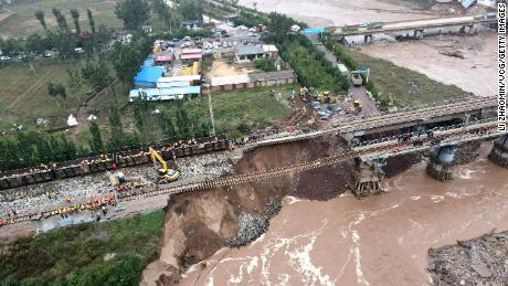 Rescuers repair a bridge damaged by flooding on October 7, 2021, in Jinzhong, Shanxi province.