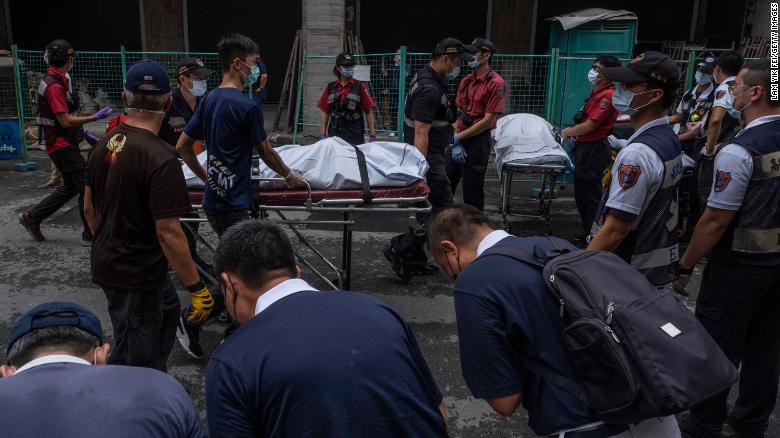 Paramedics transport dead bodies after a building fire in Kaohsiung, Taiwan, on Thursday, October 14.