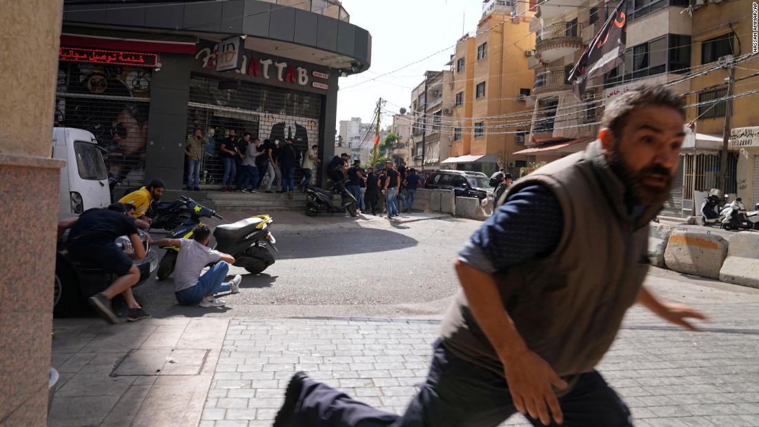 A man runs for cover as gunfire breaks out at a protest in Beirut, Lebanon, on Thursday, October 14.