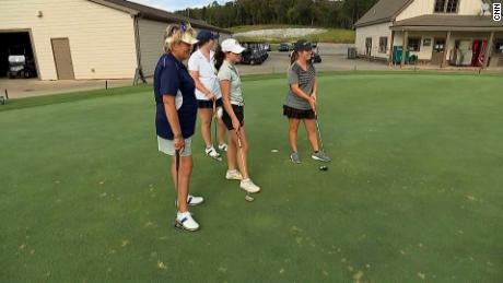 Blount (left) supports her teammates during putting practice. 