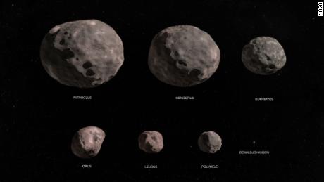 La misión Lucy de la NASA explorará siete asteroides troyanos.  Esta ilustración muestra el asteroide binario Patroclus / Menoetius, Eurybates, Orus, Leucus, Polymele y el asteroide del cinturón principal Donald Johansson.