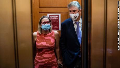 WASHINGTON, DC - SEPTEMBER 30: Sen. Kyrsten Sinema (D-AZ) and Sen. Joe Manchin (D-WV) catch and an elevator to go to the Senate Chamber to vote, after meeting in Sen. Manchins hideaway for half an hour, in the U.S. Capitol on Thursday, Sept. 30, 2021 in Washington, DC.  (Kent Nishimura / Los Angeles Times via Getty Images)