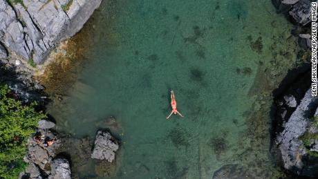 A woman swims to cool off in Lake Xhemas, a small natural lake located in Valbona National Park near Dragobi, on August 4, 2021.
