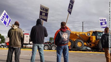 DAVENPORT, IOWA - OCTOBER 15: At truck hauls a piece of John Deere equipment from the factory past workers picketing outside of the John Deere Davenport Works facility on October 15, 2021 in Davenport, Iowa. More than 10,000 John Deere employees, represented by the UAW, walked of the job at yesterday after failing to agree to term of a new contract.  (Photo by Scott Olson/Getty Images)