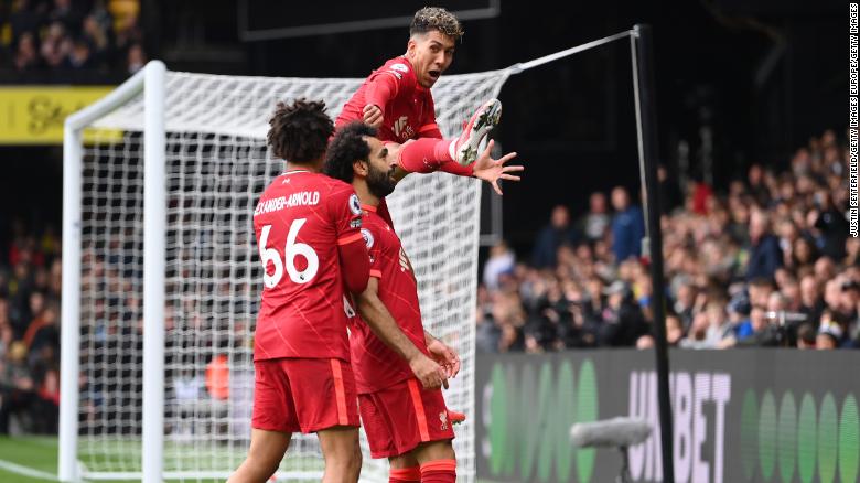 Salah celebrates with teammates Trent Alexander-Arnold and Firmino after scoring against Watford.