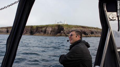 Jimmy Flannery, on his tour boat on Sunday. Behind him is a newly painted mural of Fungie that was painted on the old lighthouse and unveiled on Sunday.